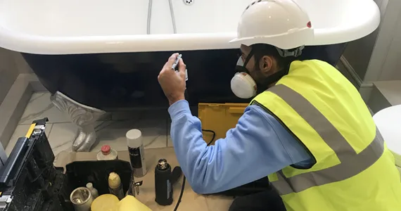 Surface Doctor technician refinishing the outside of a roll-top bath